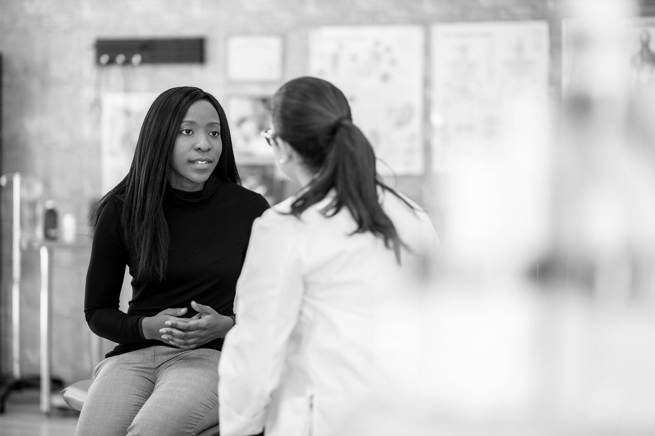 An illustration of a doctor speaking with a patient about her IBD symptoms.