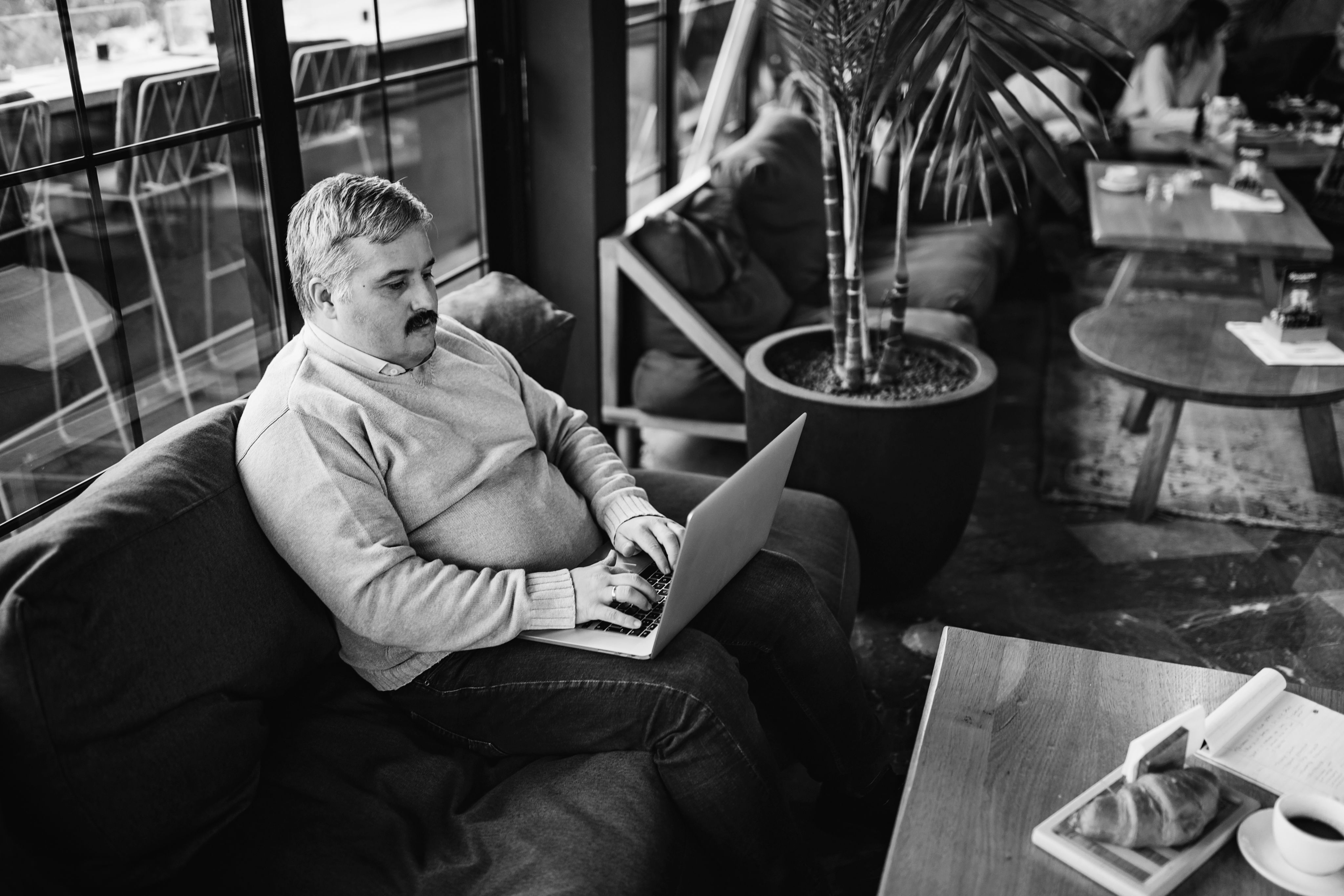 Image of a man with a mustache sitting on his computer.