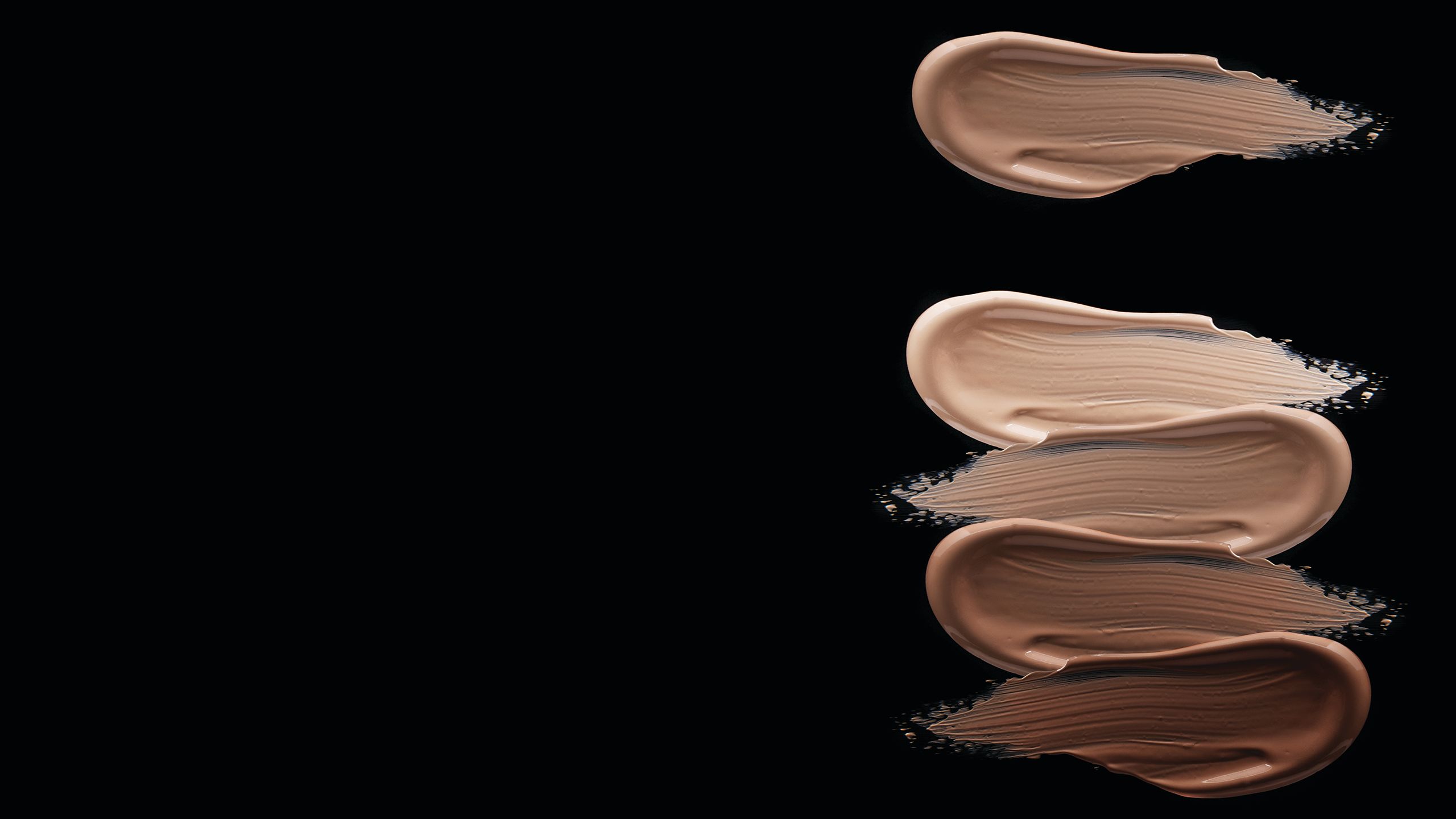 Black background image with different shades of full coverage foundation.