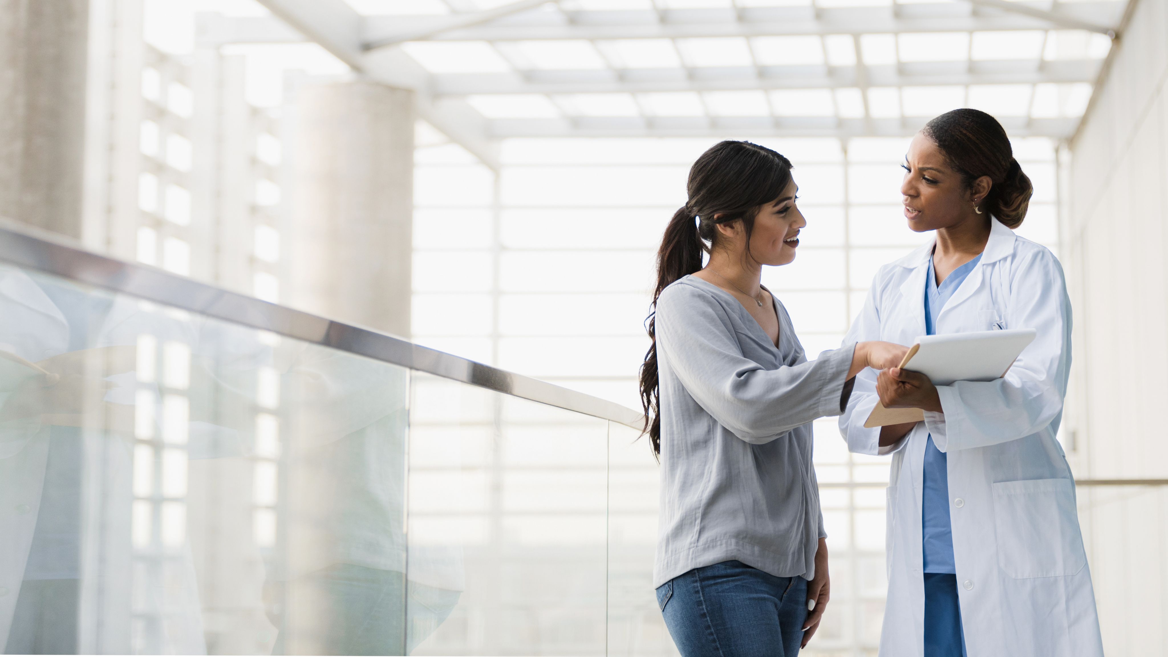 A woman speaks with her doctor about her plaque psoriasis assessment.